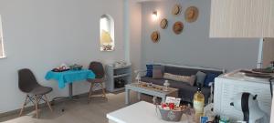 ein Wohnzimmer mit einem Sofa und einem Tisch in der Unterkunft HEAVENLY VIEWS-2-APARTMENT with POOL VIEW CLOSE TO THE BEACH! in Oropos