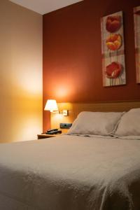 a bedroom with a bed and a red wall at Hotel Leyton in Foz