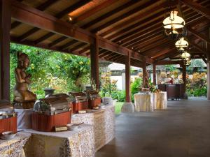 - un pavillon avec des tables et une statue de femme dans l'établissement Bintang Bali Villa, à Kuta