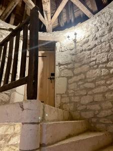 a stone building with a wooden door and stairs at L'Ancien Couvent Cahuzac in Cahuzac