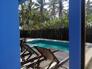a swimming pool with two chairs and a swimming pool at Nayan's Paradise in Kottanitivu