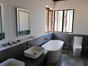 a bathroom with a sink and a toilet and a mirror at Nayan's Paradise in Kottanitivu