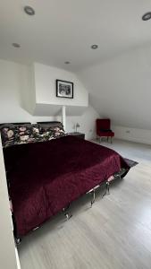 a bedroom with a bed with a red comforter at Stunning new 1 bedroom apartment in London