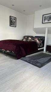 Un dormitorio con una cama con una manta morada. en Stunning new 1 bedroom apartment, en Londres
