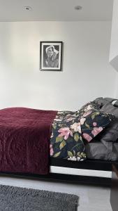 ein Bett mit einer lila Tagesdecke und einem Bild an der Wand in der Unterkunft Stunning new 1 bedroom apartment in London
