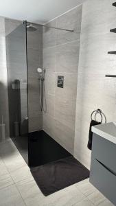 a shower with a glass door in a bathroom at Stunning new 1 bedroom apartment in London