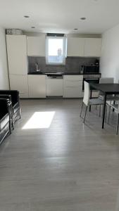 an empty kitchen with a table and chairs in a room at Stunning new 1 bedroom apartment in London