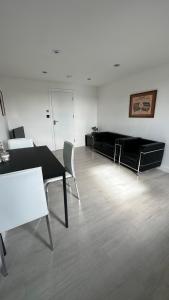 a living room with a black table and chairs at Stunning new 1 bedroom apartment in London