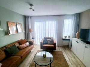 uma sala de estar com um sofá e uma cadeira em Amelander Kaap 39 em Hollum