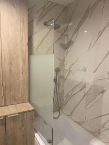 y baño con ducha y puerta de cristal. en Apartament Mgła en Zielona Góra
