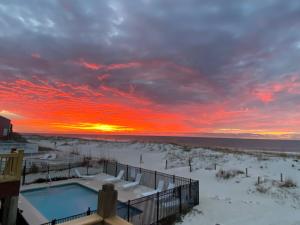 a sunset over a swimming pool in the snow at Blue Parrot in Gulf Shores