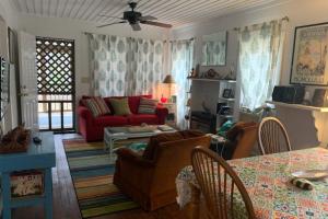 sala de estar con sofá rojo y mesa en Diver Down Cottage, en Carrabelle