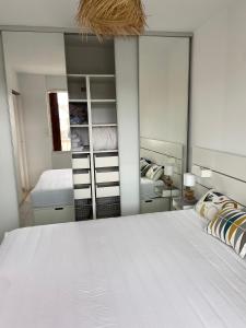 濱海聖西的住宿－La Frégate - appartement à 100 m de la plage，卧室配有一张白色大床和镜子