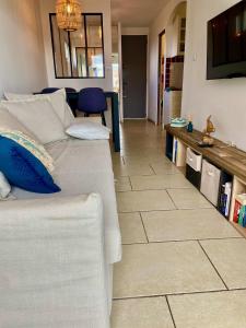 uma sala de estar com um sofá e piso em azulejo em La Frégate - appartement à 100 m de la plage em Saint-Cyr-sur-Mer