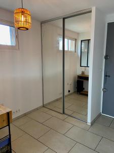 a room with a sliding glass door with a desk at La Frégate - appartement à 100 m de la plage in Saint-Cyr-sur-Mer