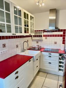 濱海聖西的住宿－La Frégate - appartement à 100 m de la plage，厨房配有白色橱柜和红色台面