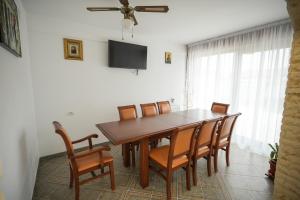 comedor con mesa de madera y sillas en Aldevis House, en Horezu
