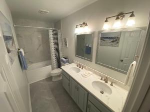 a bathroom with a sink and a toilet and a mirror at Blue Parrot in Gulf Shores