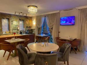 a restaurant with tables and chairs and a tv on the wall at Saint John Hotel in Selçuk