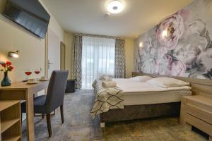 Pokój hotelowy z łóżkiem, biurkiem i biurkiem w obiekcie Villa Solaris w mieście Niechorze