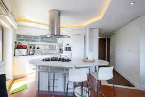 una cucina con una grande isola bianca con sgabelli di ALİZE penthouse 360*view a Istanbul
