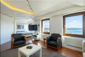 una camera d'albergo con letto, sedie e TV di ALİZE penthouse 360*view a Istanbul