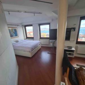 ein Schlafzimmer mit einem Bett, einem Schreibtisch und 3 Fenstern in der Unterkunft ALİZE penthouse 360*view in Istanbul