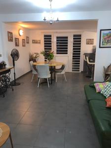 ein Wohnzimmer mit einem Sofa, einem Tisch und Stühlen in der Unterkunft Bas de villa cosy in Le Lamentin