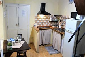 グッビオにあるRed Houseの小さなキッチン(白い冷蔵庫、テーブル付)