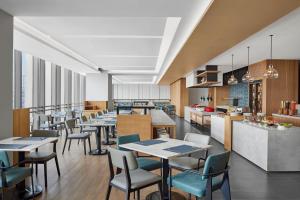 a restaurant with tables and chairs and a kitchen at Fairfield by Marriott Changzhou Jintan in Changzhou