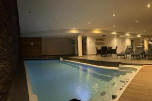 una piscina en un hotel con mesa y sillas en Superbe appartement Champex-Lac avec piscine et sauna, en Champex