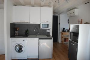 eine Küche mit einer Waschmaschine und einem Kühlschrank in der Unterkunft Gîte Le Logis Vallat Bas in Fuveau