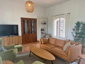 sala de estar con sofá y TV en Spacious Villa with Exceptional Views in Malaga en Casarabonela