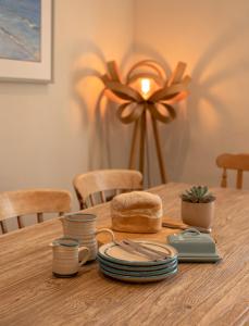 una mesa de madera con platos y pan. en Trevidgeowe Farmhouse, en Bodmin