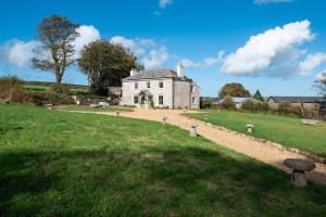 an old house on a hill with a grass field at Trevidgeowe Farmhouse in Bodmin