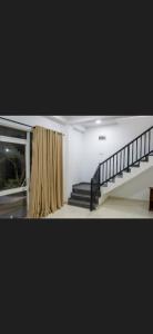 a staircase in a living room with a curtain at Pinnawala Elephant Front View Hotel in Rambukkana