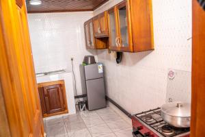 a small kitchen with a refrigerator and a stove at Plan B Complex in Buea