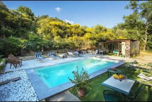 una piscina con sillas y una mesa junto a ella en Panoramic View Village of Villa Luigina Cortona, en Castiglion Fiorentino