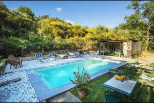 a swimming pool with chairs and a table next to it at Panoramic View Village of Villa Luigina Cortona in Castiglion Fiorentino