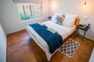 a bedroom with a large bed with a window at Glen Islay Cottage Himeville in Himeville