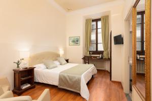 フィレンツェにあるHotel Cimabueのベッドとテレビが備わるホテルルームです。