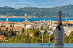 een fles wijn naast twee wijnglazen bij Stella Maris 2BDR, balcony, sea view, garage, BBQ in Zadar