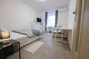 1 dormitorio con cama, escritorio y ventana en Fara No71 apart 3 en Libice nad Cidlinou