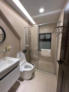 uma casa de banho com um chuveiro, um WC e um lavatório. em Traveler's Campfire B&B em Magong