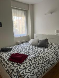 una camera da letto con un letto con due cuscini e una finestra di Cherry's House Milano M1 rossa Bande Nere - San Siro a Milano