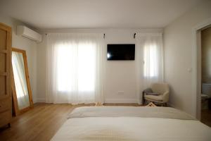 um quarto com uma cama, uma cadeira e uma televisão em Casa Verata em Losar de la Vera