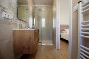 ein Bad mit einem Waschbecken, einer Dusche und einem Bett in der Unterkunft Casa Verata in Losar de la Vera