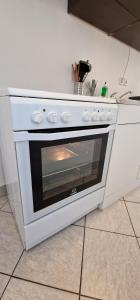 a white oven sitting on a kitchen counter at Apartman MURKO P-1 in Brest