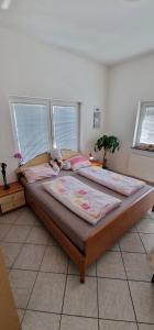 two beds in a bedroom with two windows at Apartman MURKO P-1 