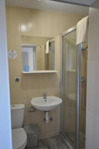 een badkamer met een toilet, een wastafel en een douche bij Dziupla Dębki in Dębki
